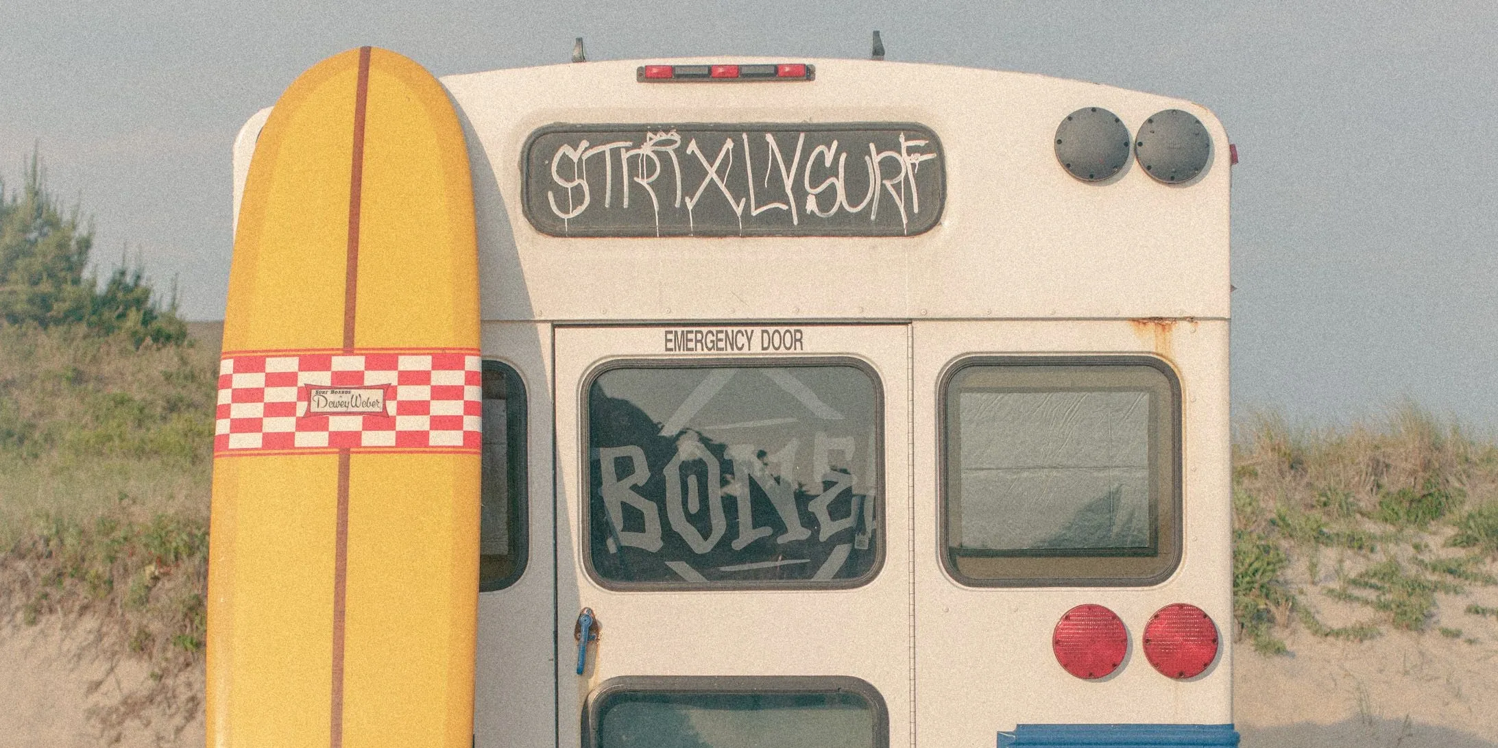 Vintage surf van with surfboard at an East End beach